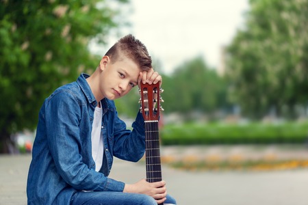 Portrait Teenager Boy with guitar in the park, outdoors.の写真素材