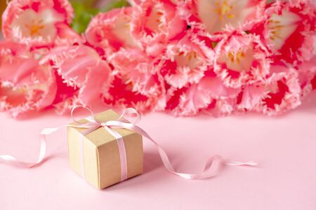 Present or gift box with Beautiful bouquet of pink tulips flowers on pink background. Card Concept for Mothers day, 8 March, Happy Birthdayの写真素材
