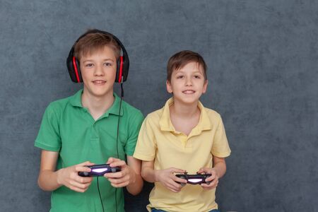 Two Friends boys enjoying playing videogame on , Resting At Home. They Plays  Wireless Controllers.の写真素材