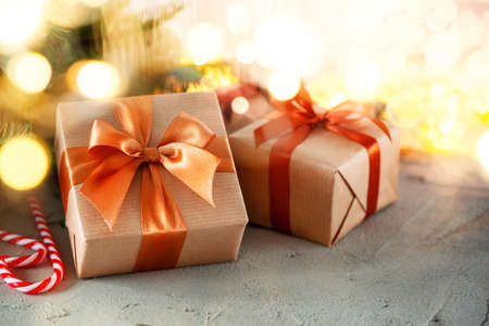 Rustic retro gifts, present boxes on bokeh background. Christmas time. Handmade paper wrap.