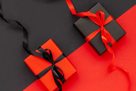 Black Friday concept. Black gift box with red ribbon and red present box with black ribbon. Flat lay