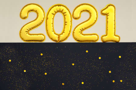 Golden digits 2021 numbers of the Happy New Year lie on a black background. Flat lay, Holiday Party Decoration or postcard concept.の写真素材