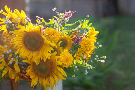Beautiful autumnal bouquet of bright yellow sunflower on sunset in countryside. Autumn still life with garden flowers.の写真素材