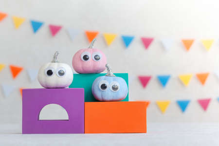 Colorful pumpkins on colourful podiums or pedestals over white background. Holiday Halloween party concept.の写真素材