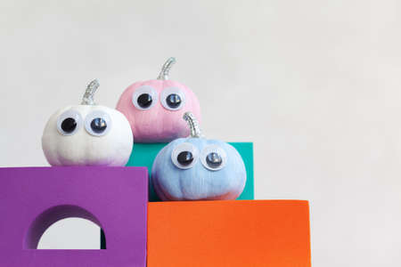 Colorful pumpkins on colourful podiums or pedestals over white background. Holiday Halloween party concept.の写真素材