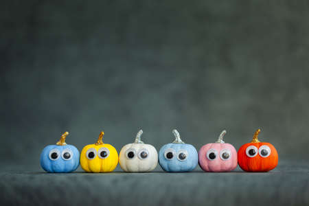 Bright colorful halloween funny face pumpkins on dark background with copy space. Greeting card for holiday halloween.の写真素材