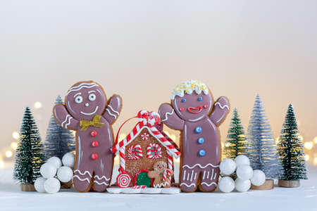 Decorated Christmas Couple Gingerbread men and gingerbread house on netural background with...