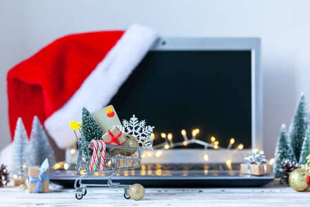 Shopping cart full of gift boxes and Christmas tree, credit card and snowflake on keyboard of laptop computer. Concept online shopping and holiday sale.の写真素材