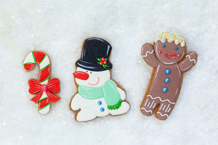 Gingerbread cookies: gingerbreadmen, snowman and candy on white table with snow. Holiday, Christmas and happy New Year. Top viewの写真素材