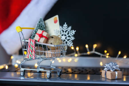 Shopping cart full of gift boxes and Christmas tree, credit card and snowflake on keyboard of laptop computer. Concept online shopping and holiday sale.の写真素材