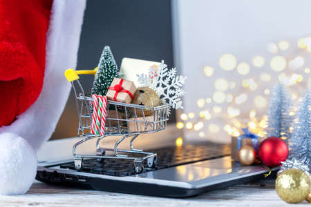 Shopping cart full of gift boxes and Christmas tree, credit card and snowflake on keyboard of laptop computer. Concept online shopping and holiday sale.の写真素材