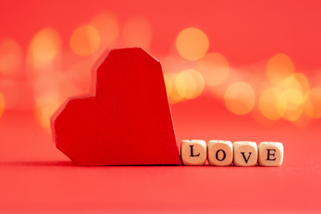 holiday concept. Red paper handmade heart with word love on red background. Creative greeting card for Saint Valentine day.の写真素材