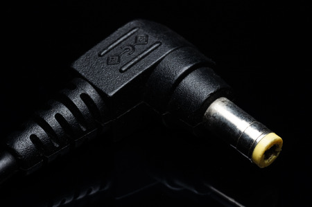 laptop charger connector isolated on blackの写真素材