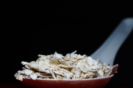 cereal in a white spoon isolated on blackの写真素材