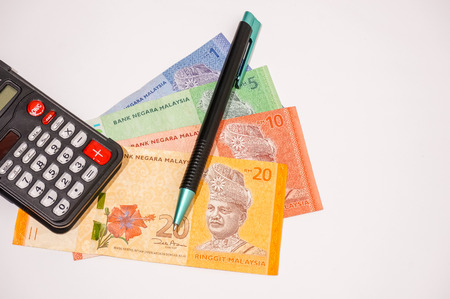 calculator and pen on bank notes isolated on whiteの写真素材