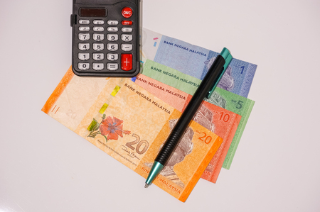 calculator and pen on bank notes isolated on whiteの写真素材