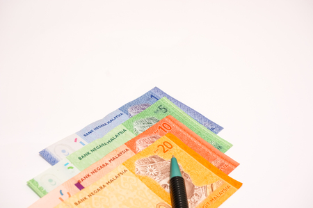 pen with bank notes isolated on whiteの写真素材