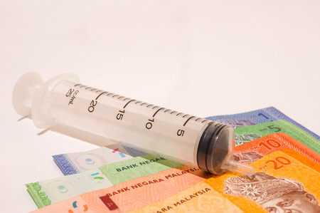 medical syringe with bank notes isolated on whiteの写真素材
