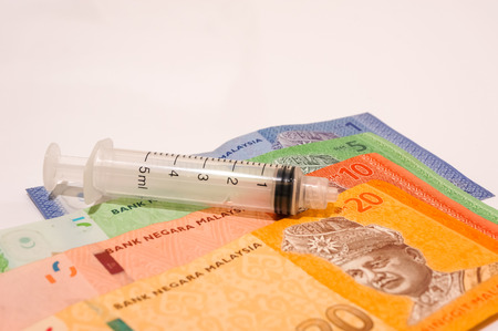 medical syringe with bank notes isolated on whiteの写真素材