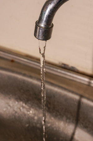 water from the tap to the sinkの写真素材
