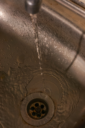 water from the tap to the sinkの写真素材