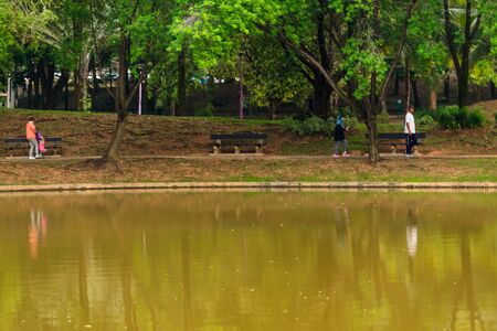 people and lifestyle concept.Motion blurred of people are running in urban park with water reflection.の写真素材