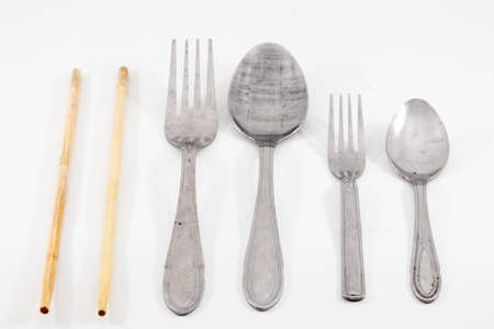 closeup shot of a spoon, fork and chopstick isolated on white backgroundの写真素材
