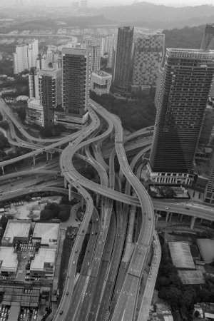 A complex highway network weaves through a dense urban landscape, showcasing the intricate infrastructure of a modern city.の写真素材
