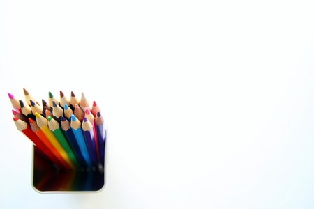 A lot of colored pencils inside a tin can on the white background.の写真素材