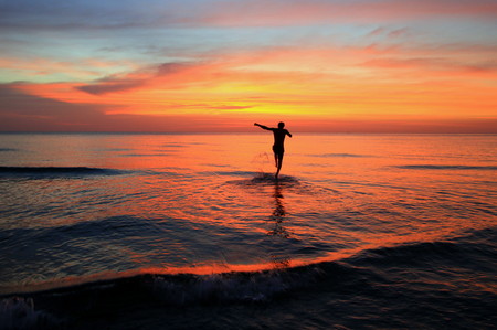 Travel to island Koh Chang, Thailand. The walking man on the beach on the colorful sunset.の写真素材