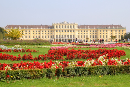Travel to Vienna, Austria. The view on the Schonbrunn Palace and park in front of him with red and white flowers in the sunny day.のeditorial素材