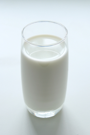 A glass of milk on the white background.の写真素材