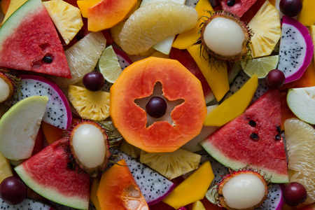 Mixed ripe and fresh fruits closeup for colorful background. Dragon fruit, pineapple, papaya, lime, mango, pomelo, rambutan, plum, watermelon.の写真素材