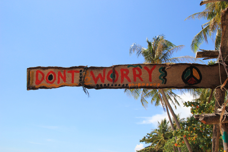 Travel to island Koh Lanta, Thailand. An inscription âDonât worryâ on the wooden abandoned hut on a sky background.の写真素材