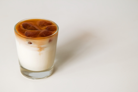 A glass of milk with coffee ice on the white background.の写真素材