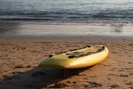 Travel to island Phuket, Thailand. Yellow surfboard on the sand beach with sea on background.の写真素材