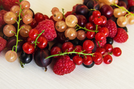 Mixed summer berries (raspberry, blackcurrant, redcurrant, white currant, gooseberry, cherry) on the white wooden background.の写真素材