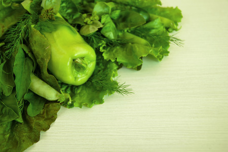 Green vegetable (salad, basil, dill, sorrel, peas, pepper, cucumber) on the white wooden background.の写真素材