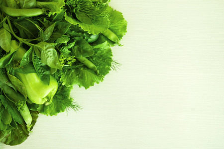 Green vegetable (salad, basil, dill, sorrel, peas, pepper, cucumber) on the white wooden background, top view.の写真素材