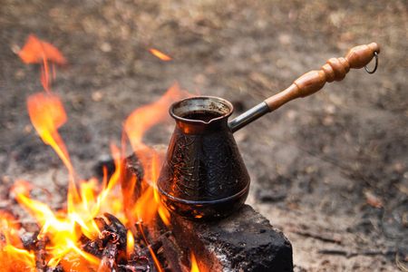 Metal cezve with hot flavored coffee on a bonfire closeup.の写真素材