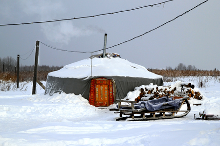 An yurt  with the sleigh on a white snow. Winter landscape.の写真素材