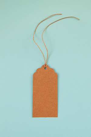 Brown blank paper price tag or label set on the blue background, top view.の写真素材