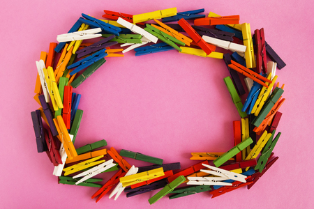 Frame from wooden colorful pins on the pink background with copy space.の写真素材