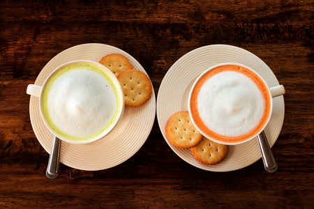 The couple cups with colorful Thai milk tea on the brown wooden background, top view.の写真素材