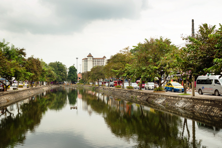 CHIANG MAI, THAILAND - NOVEMBER 23, 2017: View on the city and roads with cars, taxi, motorbikes near to channel at the cloudy day.のeditorial素材
