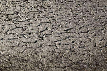 Dry cracked black stony soil polluted heavy metals.