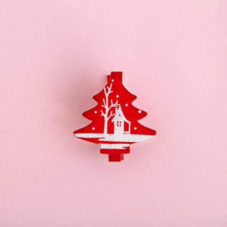 Red wooden Christmas and New Year decoration in the form of Christmas tree on a pink background, top view.の写真素材