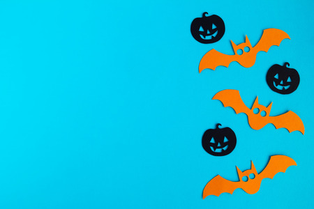 Holiday decorations for Halloween. Orange paper bats and black paper pumpkins on a blue background, top view.の写真素材