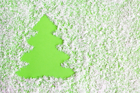 Winter composition with Christmas tree on a green background with artificial snow, flat lay. Greeting card for New Year with copy space.の写真素材