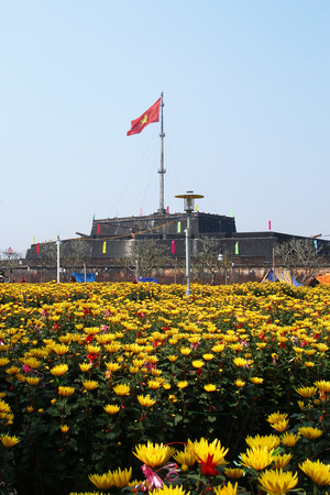 Hue, Vietnam - February 10, 2018: Hue Imperial City. View on Citadel with Vietnamese flag and yellow flowers of chrysanthemums before celebration of Tet - Vietnamese New Year.のeditorial素材